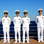 **

"A group of young, smiling Russian sailors in their navy uniforms, standing on the deck of a modern Russian warship during a sunny day. The ship is at sea, with a clear blue sky and calm waters in the background. The sailors are fully clothed in appropriate naval attire. Safe for work, appropriate content, modest, family-friendly, professional. Perfect anatomy, correct proportions, natural pose, well-formed hands, proper finger count, natural body proportions. High quality, professional photography."

**